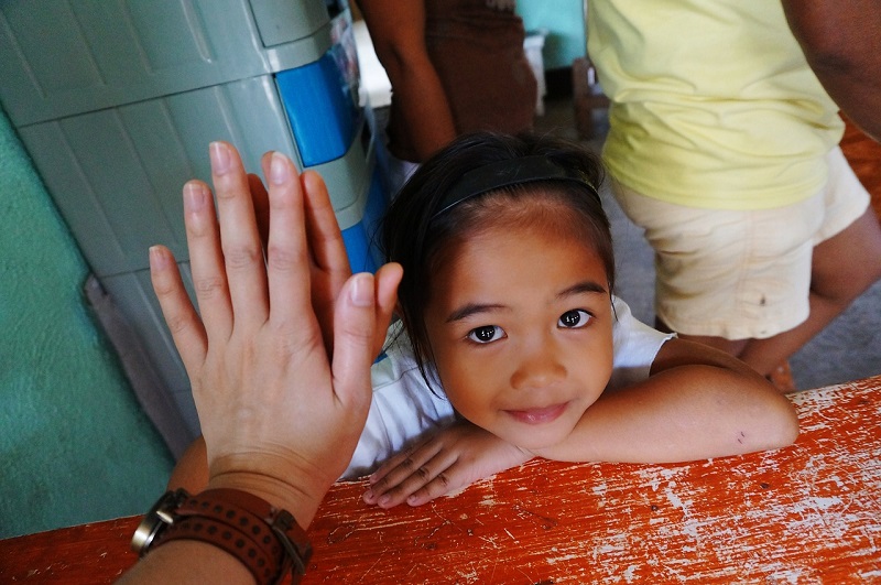 A woman touching hand of a little girl